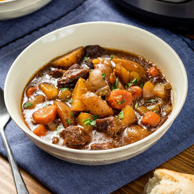 Slow cooker simmering beef stew, aroma filling kitchen with McCormick flavor.