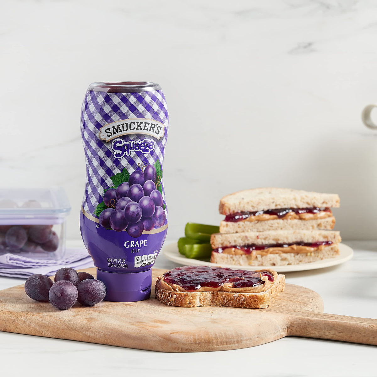 Smucker's grape jelly being poured on pancakes for easy portioning