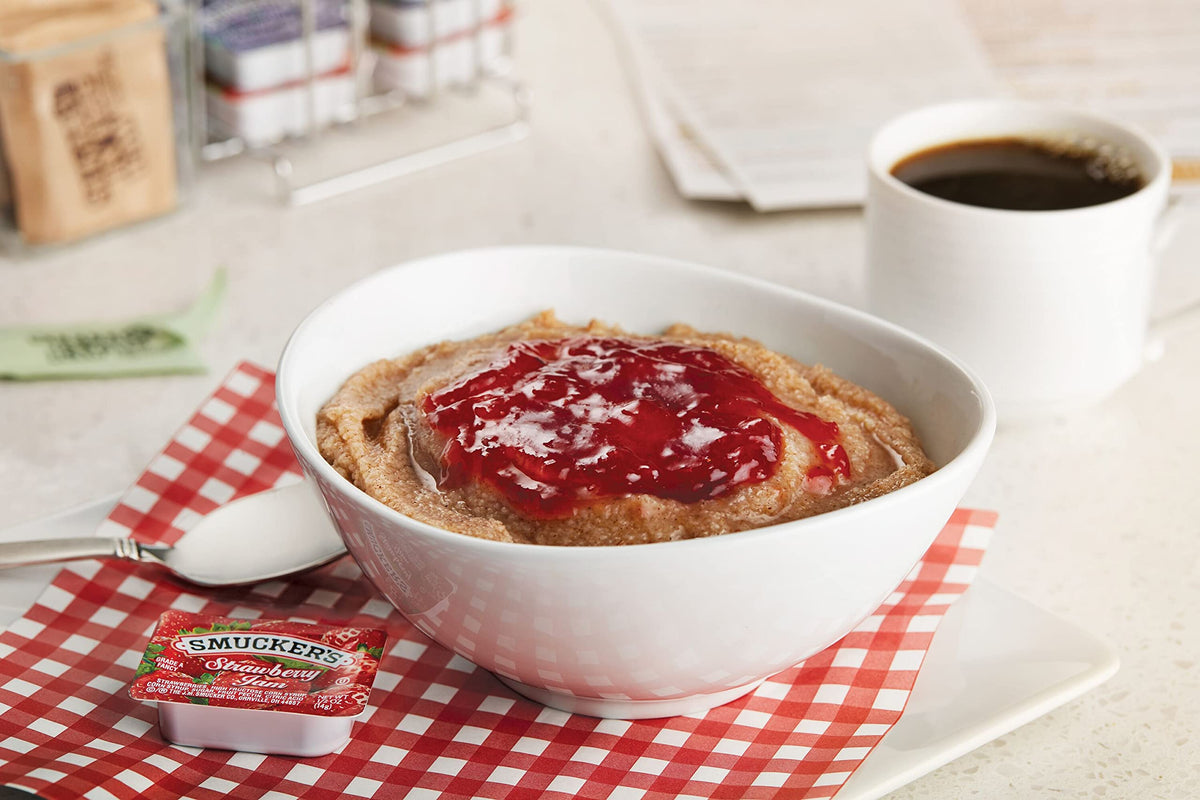 Smucker's strawberry jam half-ounce cups on a tabletop caddy for easy portion control and service.
