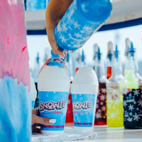 Shaved ice station featuring Snowie flavor concentrate for homemade snow cones.