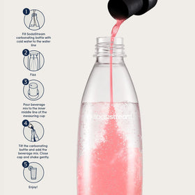 Pouring SodaStream Pink Grapefruit into sparkling water with bubbles