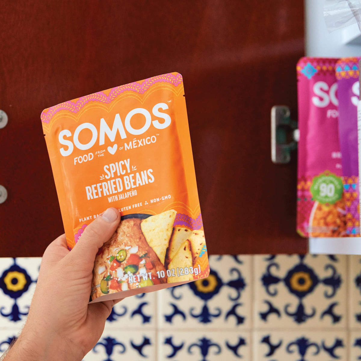 SOMOS refried beans on pantry shelf, ready for tacos or bowls.
