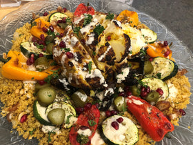 Vibrant spices including turmeric and herbs on vegetables with SPICE + LEAF.
