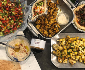 Shawarma spice bottle pouring over chicken illustrates quick, flavorful meal prep.