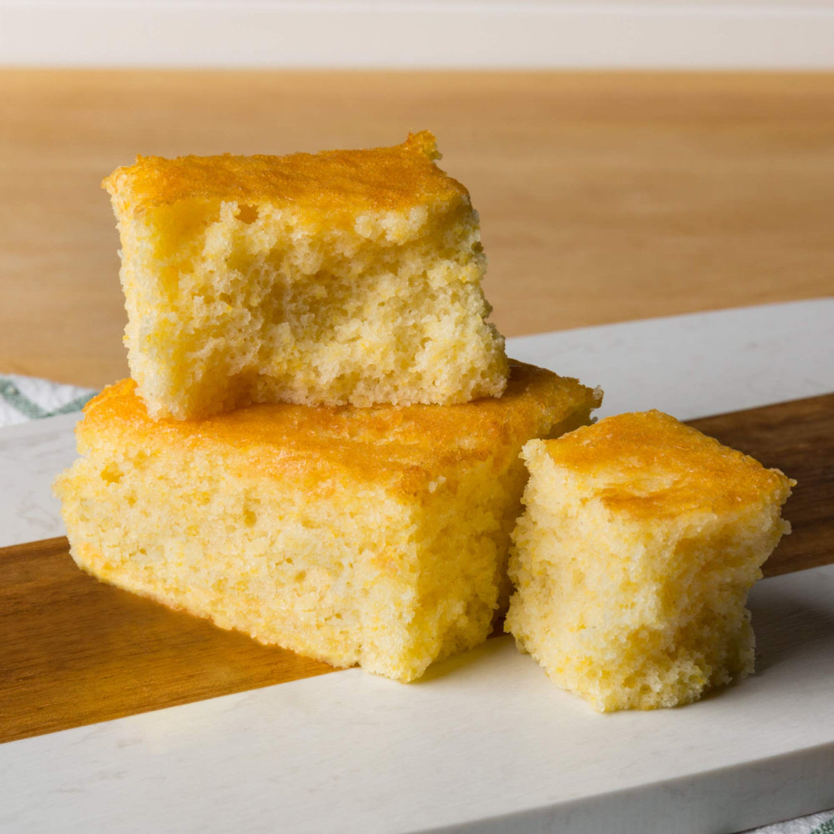 Spicy World yellow corn flour bag with bread dough and freshly baked loaves nearby.