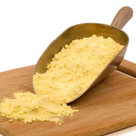 Spicy World yellow corn flour bag beside a tortilla press for homemade tortillas.