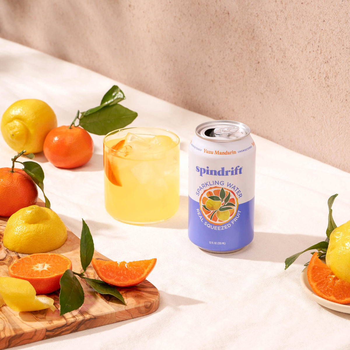 Spindrift Yuzu Mandarin can on a table with lemon twist suggests refreshing choice.