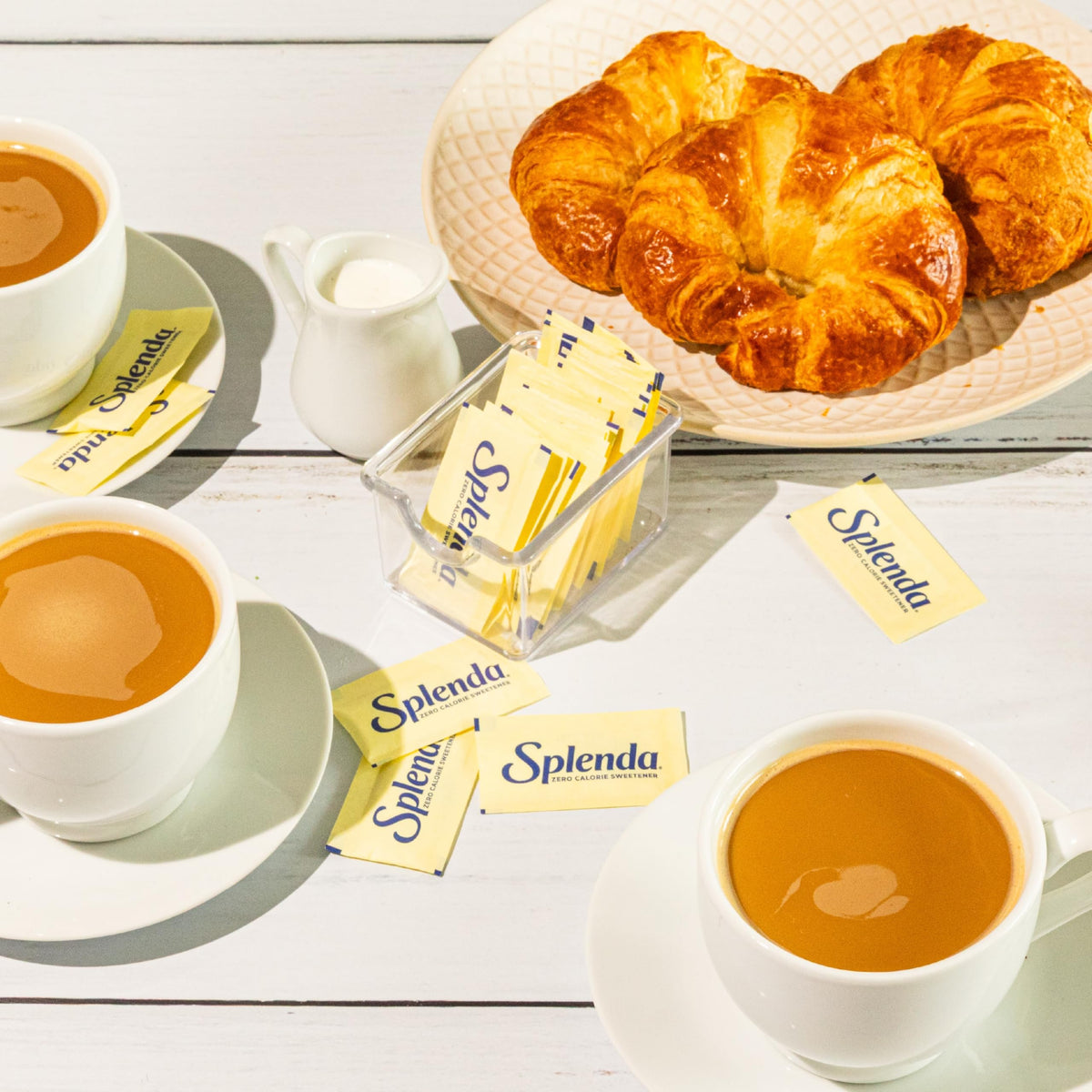 SPLENDA packets being stirred into a hot drink.