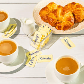 SPLENDA packets being stirred into a hot drink.