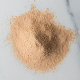 Sprout Living organic lucuma powder packaging shown on kitchen counter.