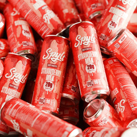 Spylt strawberry milk on surface with branding and packaging visible.