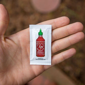 Sriracha2Go 6g packet close-up of smooth chili paste.