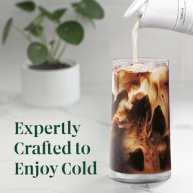 Pouring Starbucks iced coffee over ice in a glass