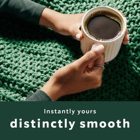 Starbucks Instant Coffee being stirred into hot water for a quick cup.