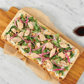 Salmon served with crackers and greens, a balanced snack option.