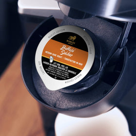Steaming cup with Marley Coffee Buffalo Soldier capsules ready for brewing.