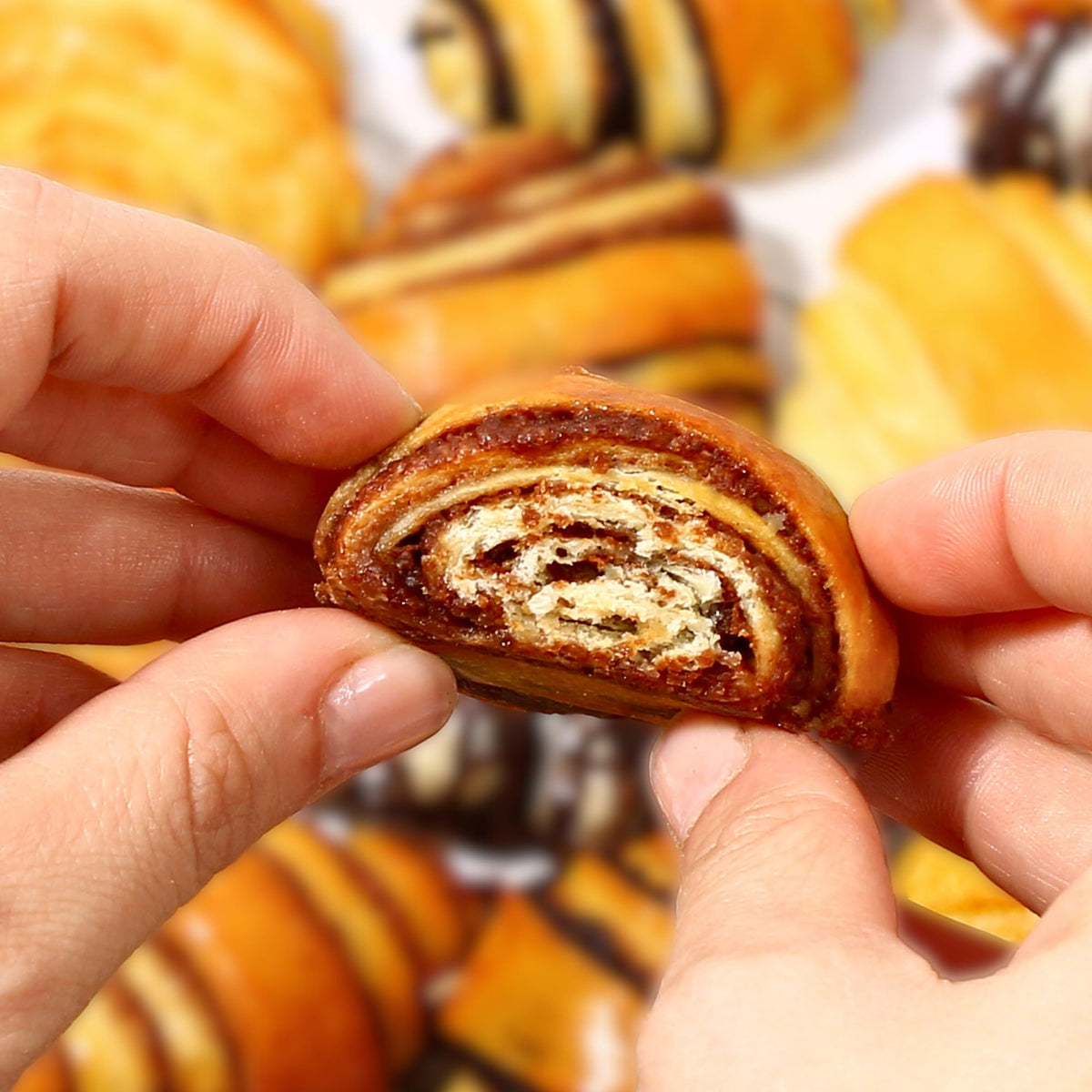 A freshly rolled cinnamon roll with a glossy cinnamon swirl.