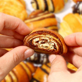 A freshly rolled cinnamon roll with a glossy cinnamon swirl.
