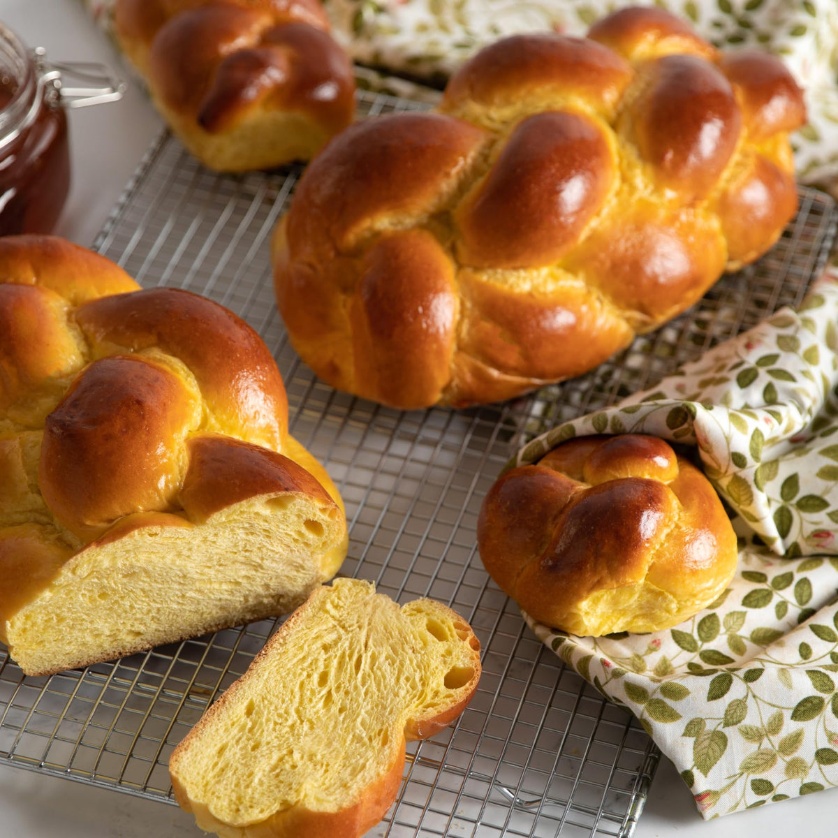 Challah rolls arranged for Shabbat table, inviting butter and spreads.