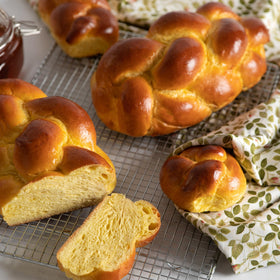 Challah rolls arranged for Shabbat table, inviting butter and spreads.