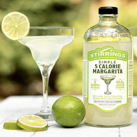 Stirrings Margarita Mix setup with glass and lime for entertaining.
