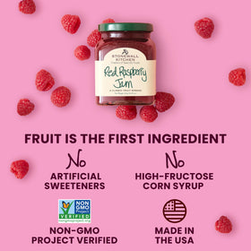 Stonewall Kitchen red raspberry jam in glass jar with fresh berries backdrop