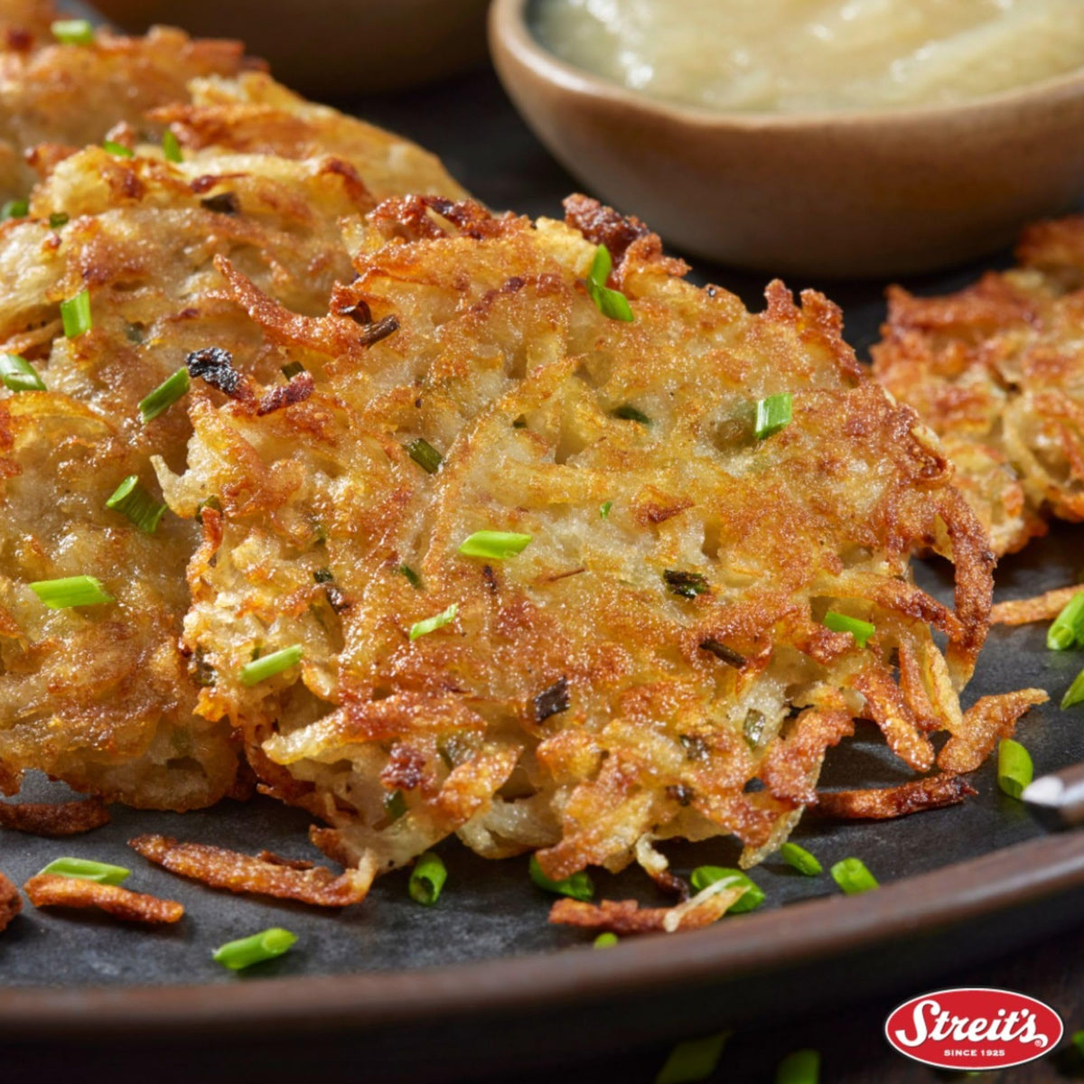 Streit's cooked potato pancakes plated with applesauce, highlighting savory-sweet serving.