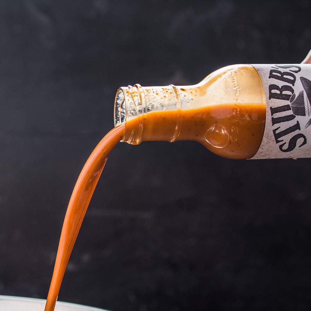 Stubb's Moppin' Sauce bottle beside brisket, hinting at juicier results.