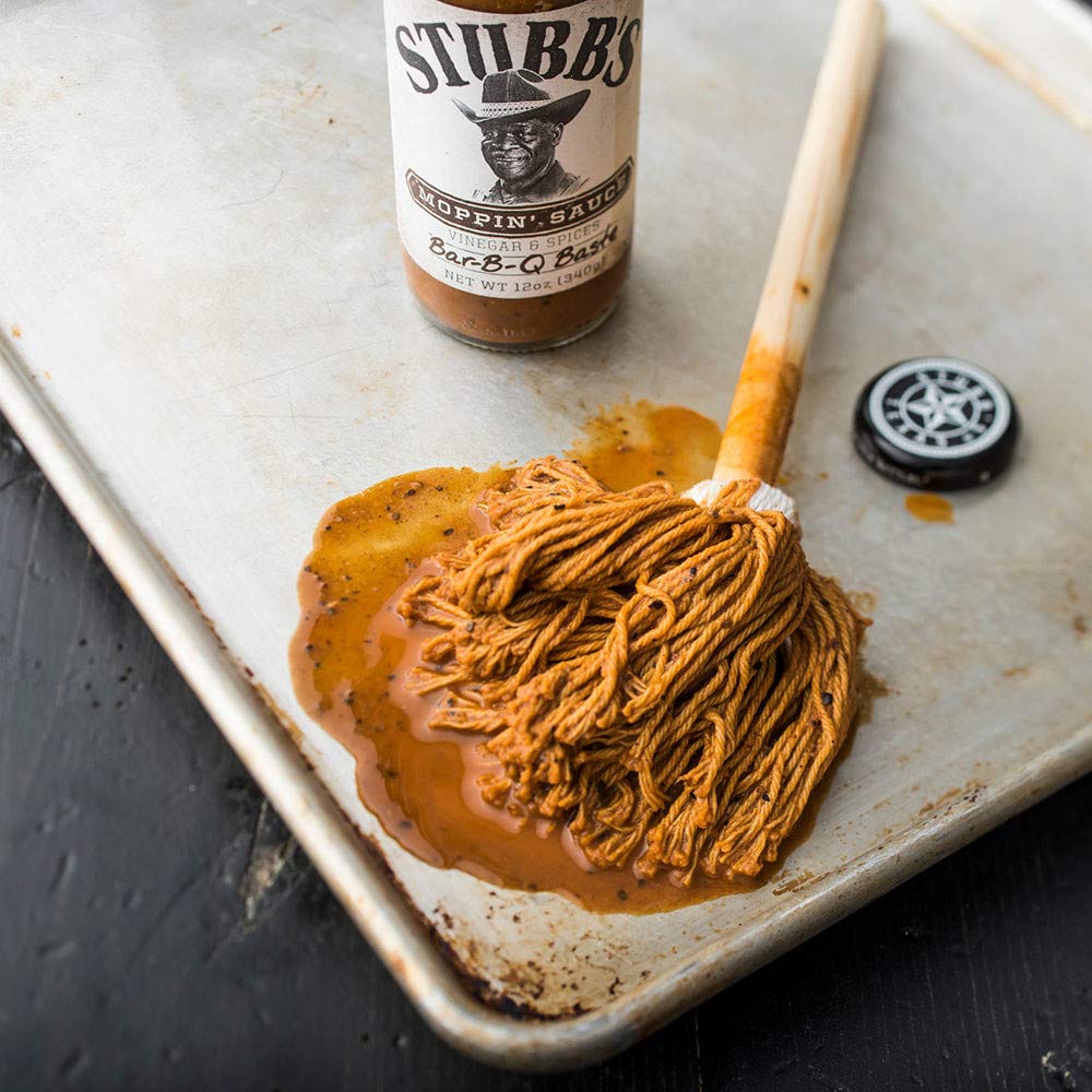 Pork shoulder being basted with Stubb's Moppin' Sauce.
