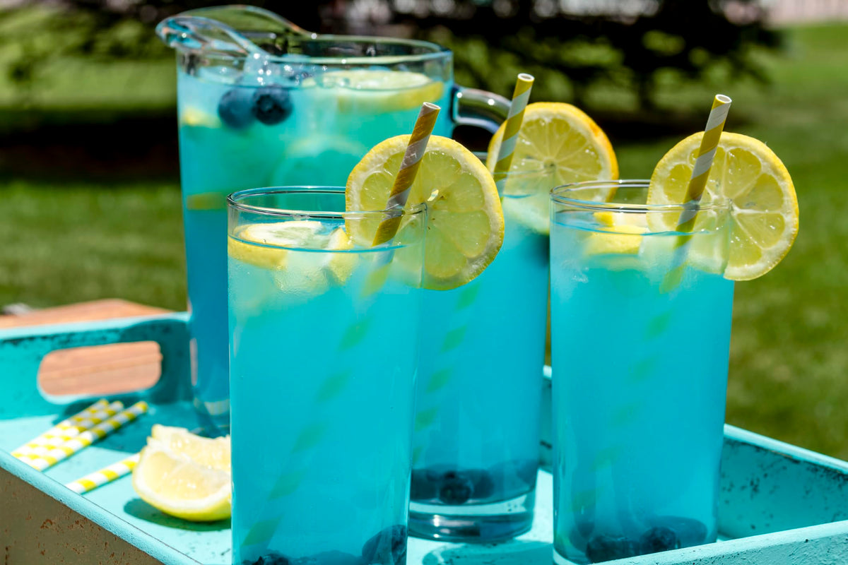 Bottle beside a glass of lemonade suggesting versatile beverage use.