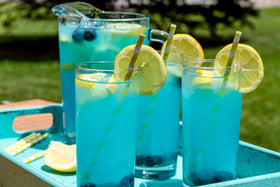 Bottle beside a glass of lemonade suggesting versatile beverage use.