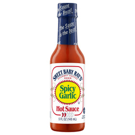Sweet Baby Ray's Spicy Garlic hot sauce being poured over wings for heat