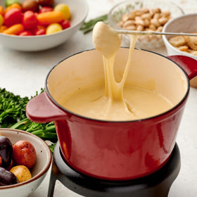 Bread, vegetables, and charcuterie ready to dip into warm fondue.
