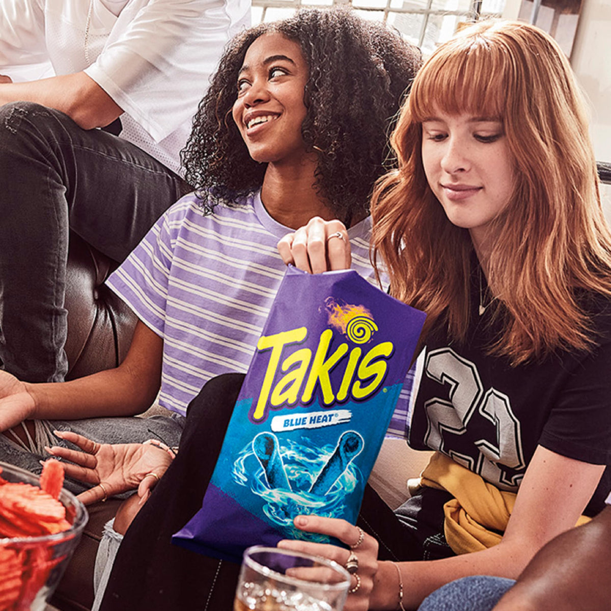 Person holding Takis Blue Heat bag, perfect for on-the-go snacking.