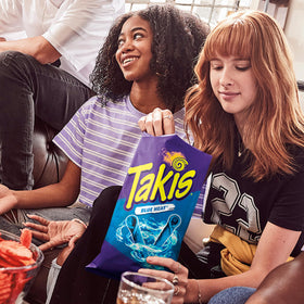Person holding Takis Blue Heat bag, perfect for on-the-go snacking.