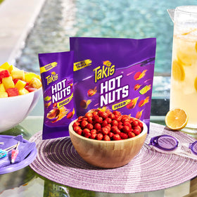 Takis Fuego Hot Nuts pack on table, convenient travel snack for adventures.