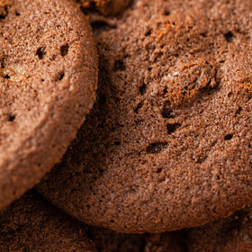 Tate's Bake Shop cookies with evenly distributed semi-sweet chips in a dark base.