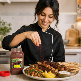 Pouring Tazah Sumac Spice onto a dish for enhanced flavor.