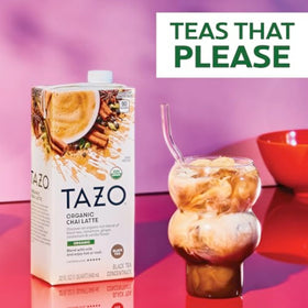 Pouring TAZO Organic Chai Latte concentrate into milk for a creamy latte.