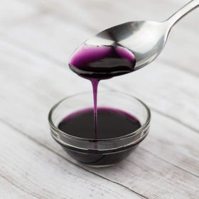 Pouring Tea Zone Blueberry Syrup into a glass for a vibrant beverage.