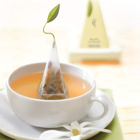 Tea Forte Cherry Cosmo pyramid tea bag steeping for a bright cup.