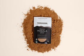 Terrasoul Masala Chai in a glass mug with steam and warm lighting.