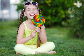 The Dreidel Company rainbow swirl lollipop, vibrant party treat for celebrations.