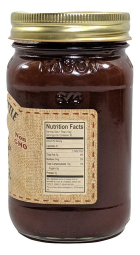 The Dutch Kettle Apple Butter jar with a wooden spoon, ideal for baking glaze.