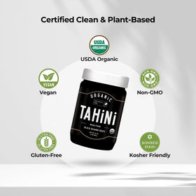 Pouring black tahini dressing made with The Holly Tree over greens.
