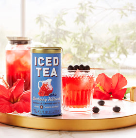A steeped The Republic of Tea Blueberry Hibiscus Iced Tea in a clear glass showing rich color.