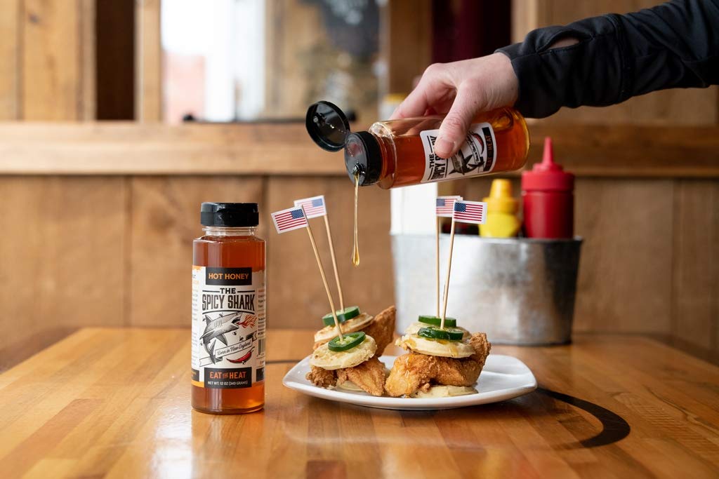 The Spicy Shark Hot Honey bottle emphasizes gluten-free and vegan-friendly attributes.