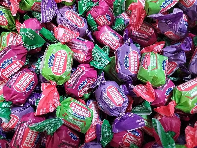 TheCandyCo Dubble Bubble bulk display with watermelon, grape, and apple flavors.