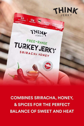 Think Jerky Sriracha Honey Turkey Jerky on a chopping board beside fresh herbs.