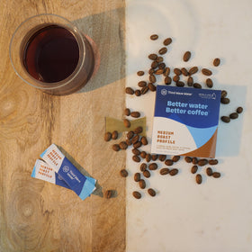 A glass of coffee brewed with Third Wave Water Medium Roast shows enhanced clarity.